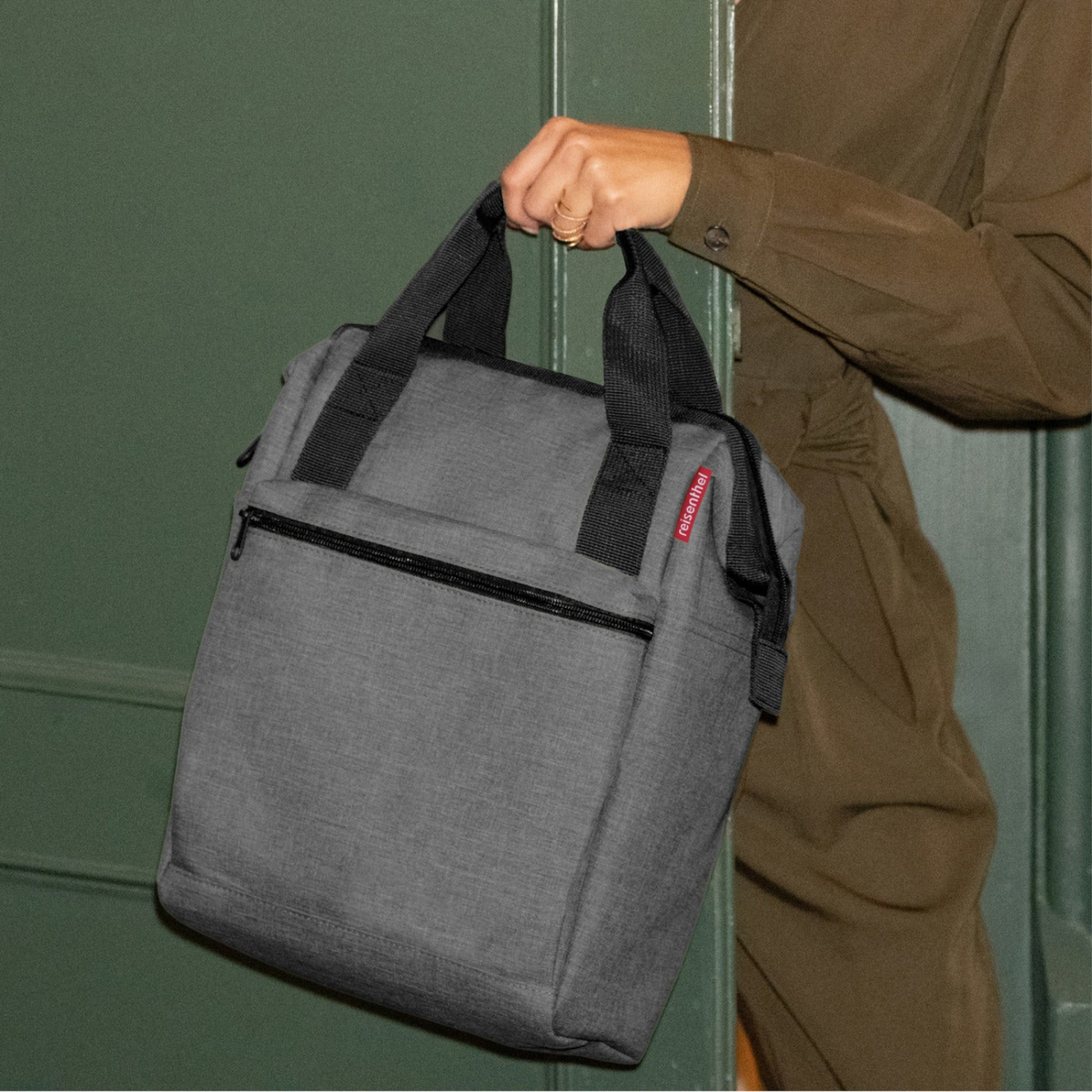 Lieblingstasche Allrounder R insulated grey thermal bag with black handles held by a person in a green outfit