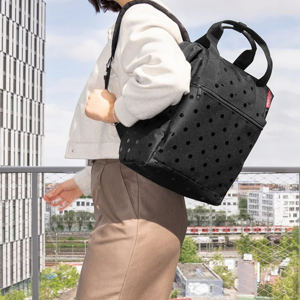 Lieblingstasche Allrounder R insulated backpack in black with polka dot pattern worn by a woman outdoors