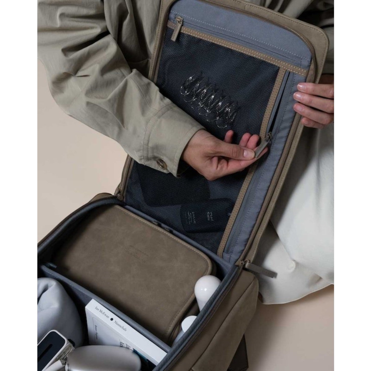 Lieblingstasche Bali Pro backpack interior with mesh pocket, organizer pouch, book, and accessories. Beige.