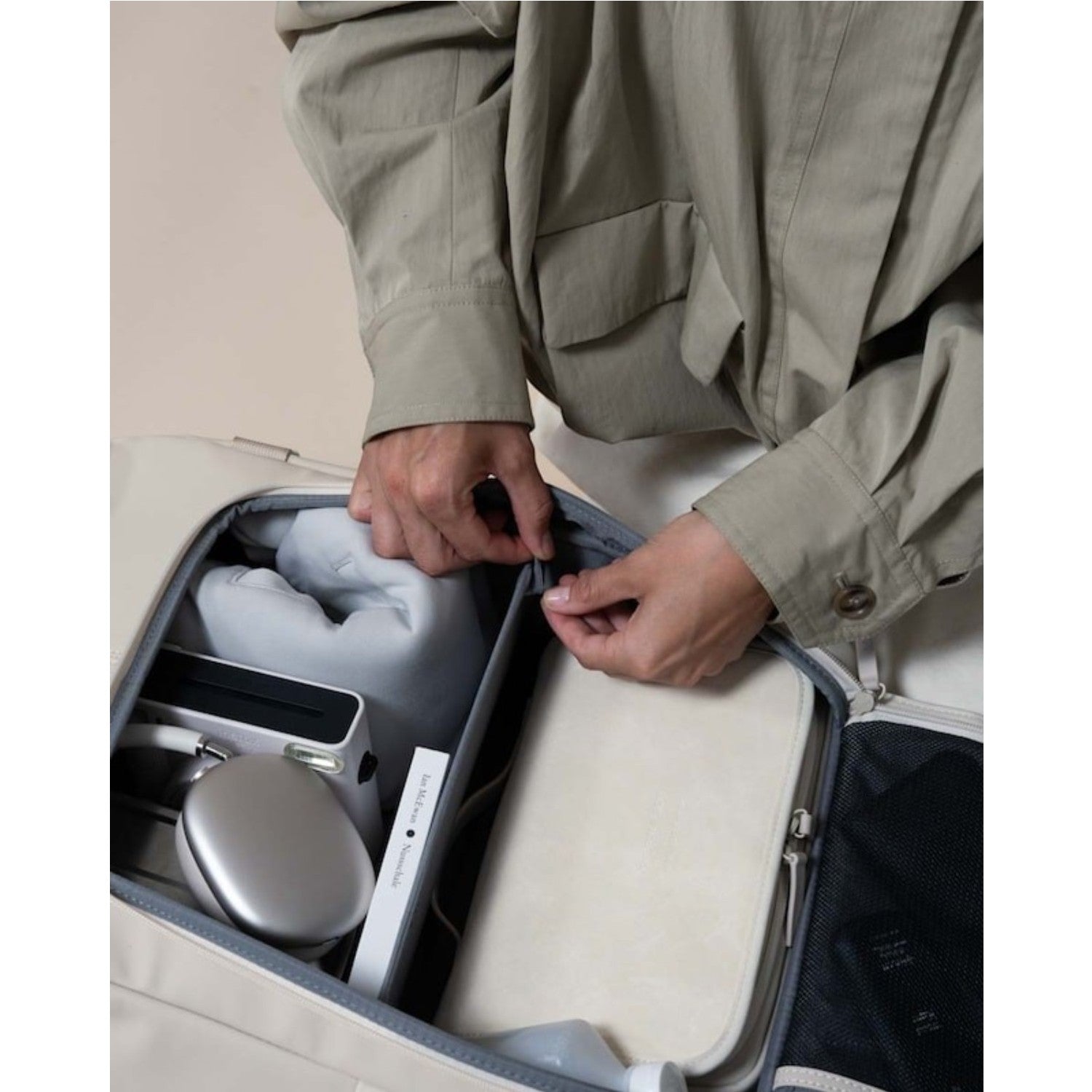 Lieblingstasche Bali Pro beige travel bag interior with organized compartments holding electronics, book, and clothing.