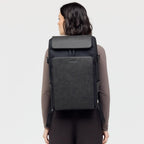 Lieblingstasche Bali Pro black backpack with faux leather front panel and adjustable straps, worn by a woman.