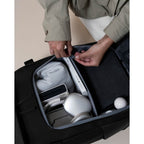 Lieblingstasche Bali Pro black backpack interior with organized tech accessories, headphones, and book.