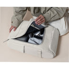 Lieblingstasche Bali Pro light grey backpack with open main compartment showing tech accessories and a person's hands organizing items.