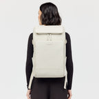Lieblingstasche Bali Pro light grey vegan leather backpack with multiple pockets and zippers, worn by a woman.