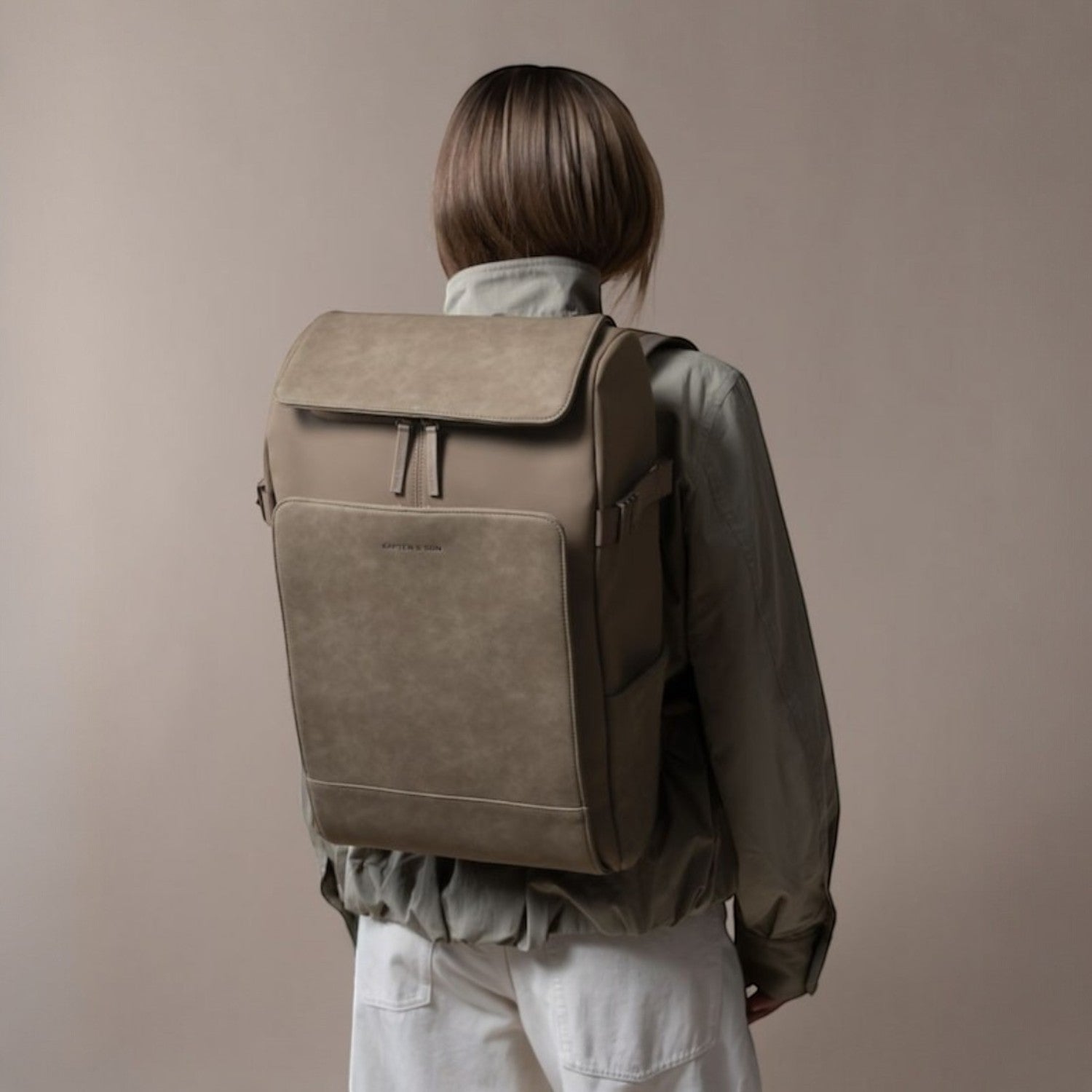 Lieblingstasche Bali Pro taupe faux leather backpack with zip pocket and side pockets, worn by a model.