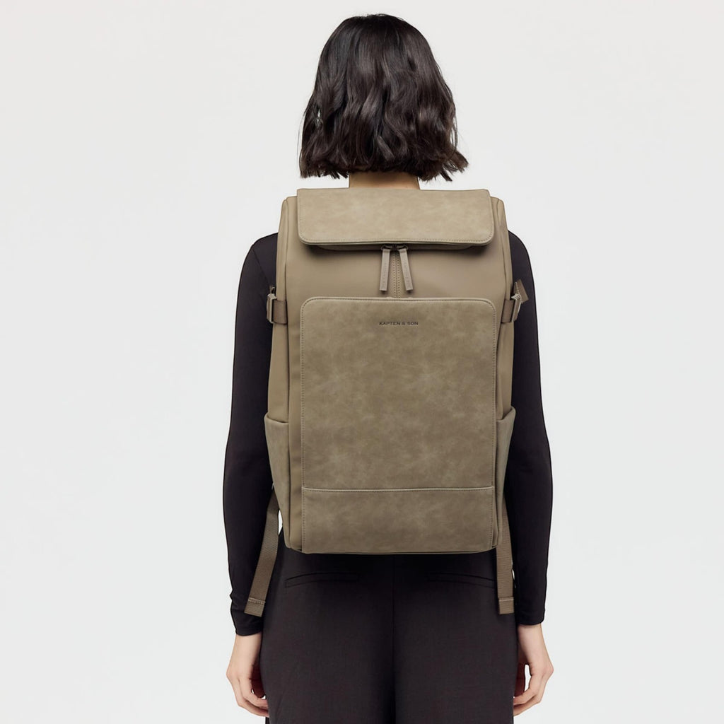 Lieblingstasche Bali Pro taupe faux leather backpack with flap closure and front pocket, worn by a model.