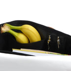 Lieblingstasche Barkasse Mini black canvas bag with internal pockets holding bananas, pens, and a notebook.