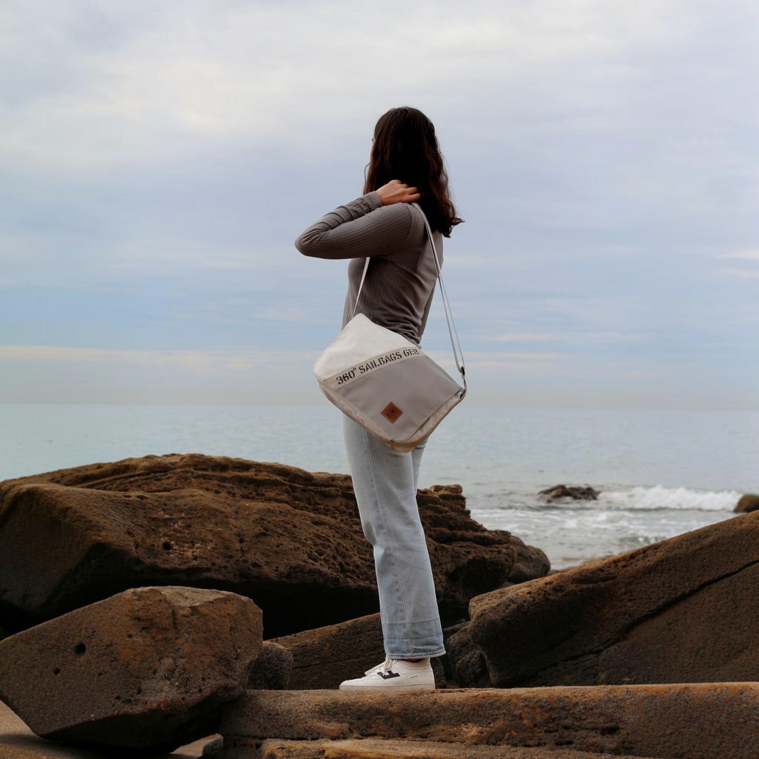 Lieblingstasche Barkasse Mini messenger bag made from recycled white sailcloth worn by a woman at the beach