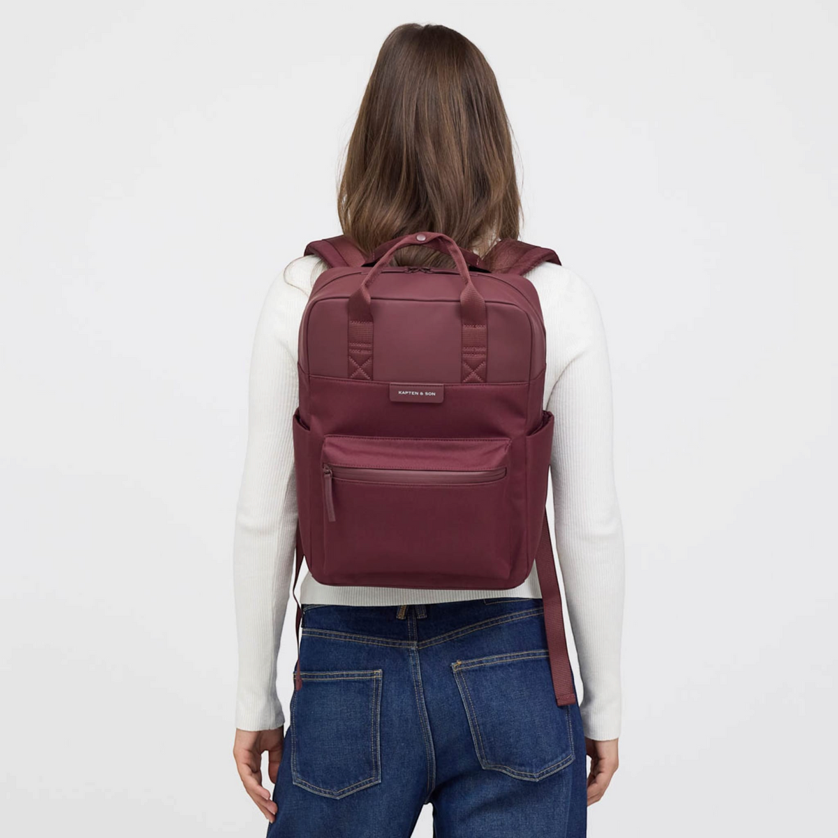 Lieblingstasche Bergen Pro backpack in burgundy worn by a woman against a white background