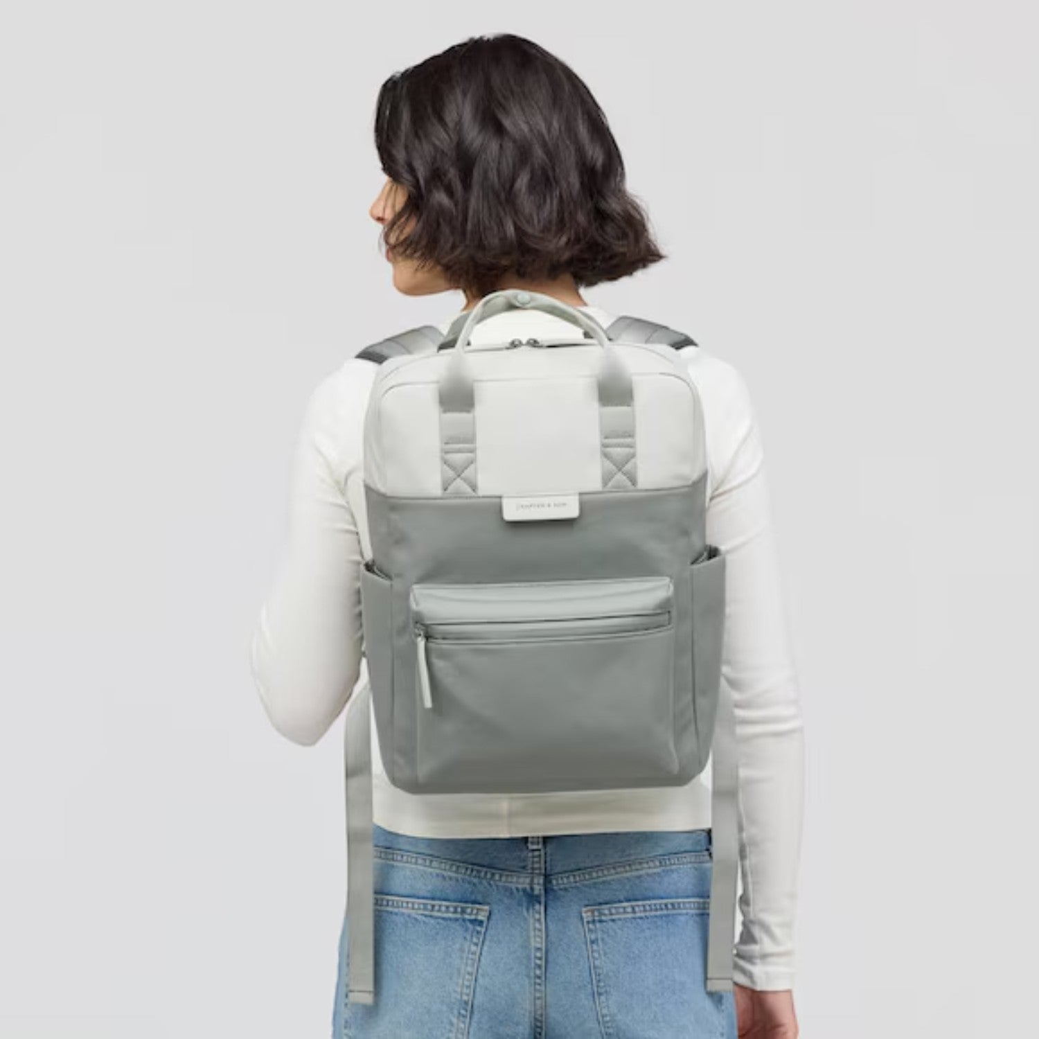 Lieblingstasche Bergen Pro backpack in two-tone grey with padded straps worn by a woman against a white background