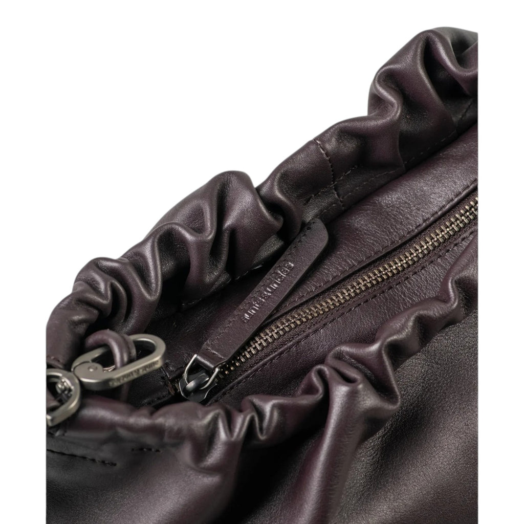 Close-up of the Lieblingstasche Bloom handbag in dark purple leather with a gathered ruched top and zipper closure.
