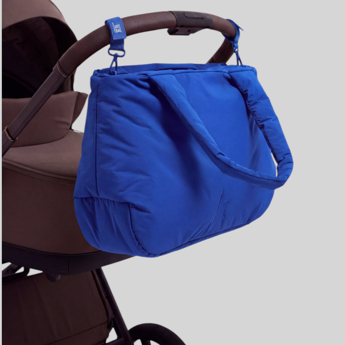 Lieblingstasche Cloud Horizon tote bag in vibrant blue, attached to a brown stroller handle with blue straps.