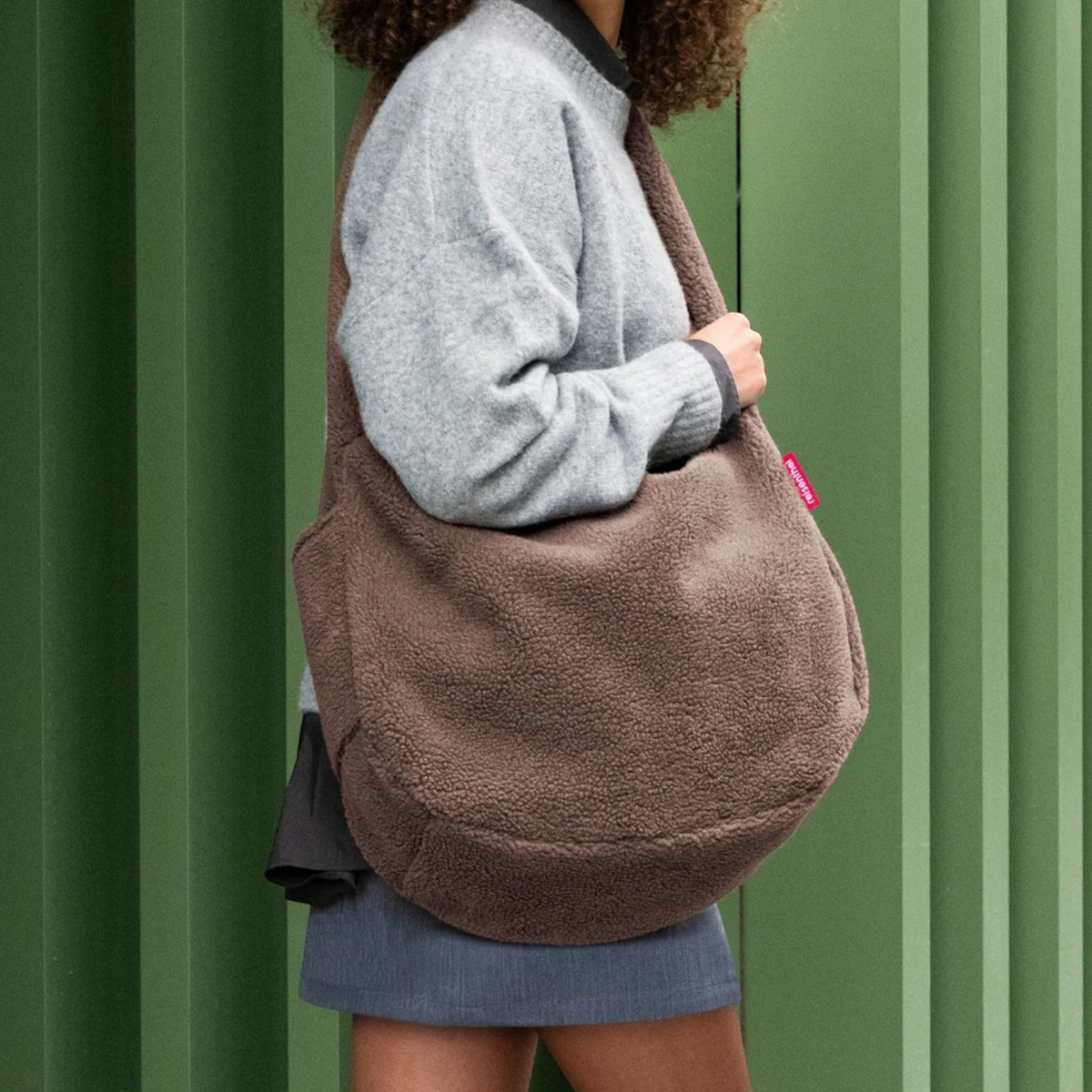 Lieblingstasche brown teddy fleece moonbag worn over the shoulder by a woman in a grey sweater