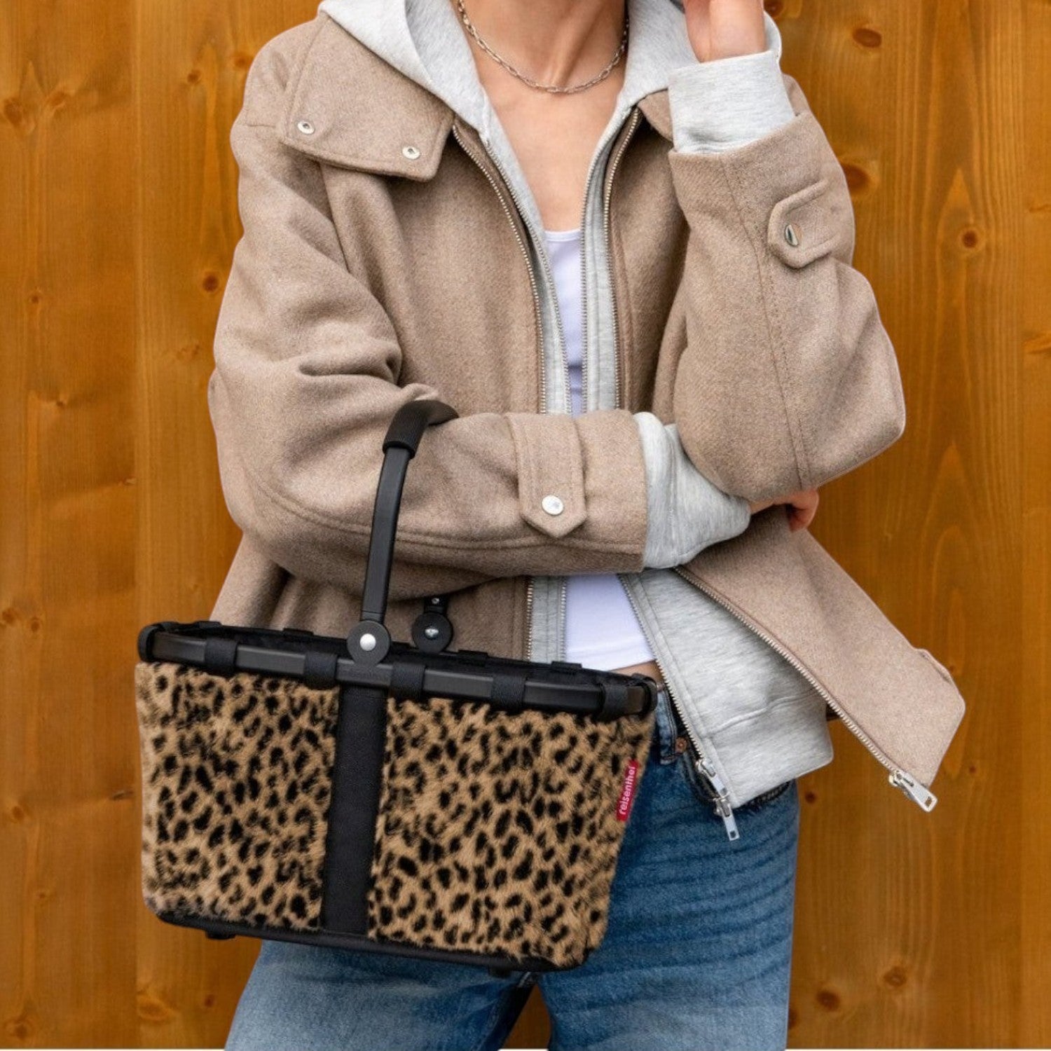 Lieblingstasche Carrybag XS featuring a leopard print faux fur exterior and black frame held by a stylish woman.