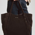 Lieblingstasche Pretty Wonder Suede dark brown leather tote bag with gold stud accents held by a woman