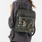 Woman wearing a Lieblingstasche dark grey patterned backpack with artistic graphic details on the front pocket