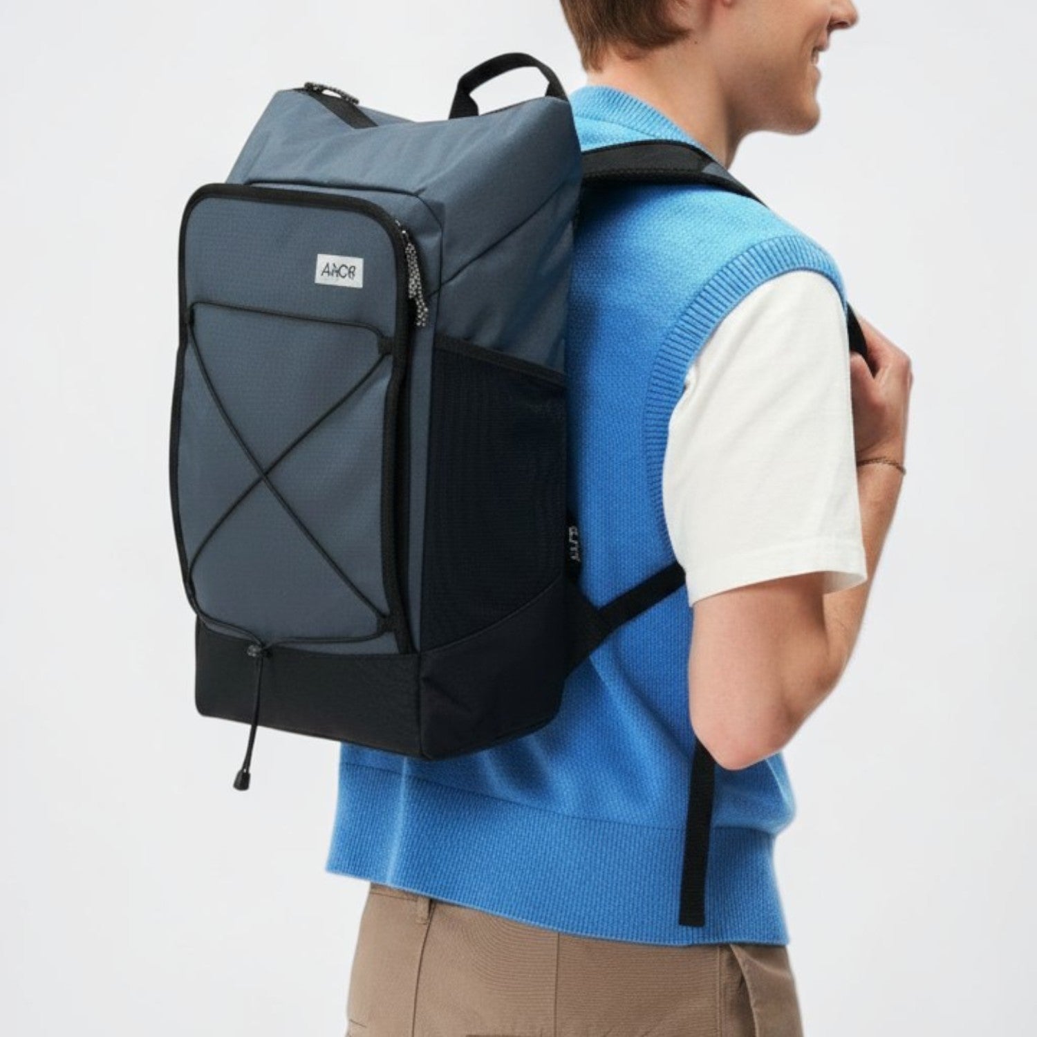 Lieblingstasche Day Pack FLX in blue and black with front bungee cord and mesh side pockets worn by a model