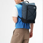 Lieblingstasche Day Pack FLX in blue and black worn by a model against a white background