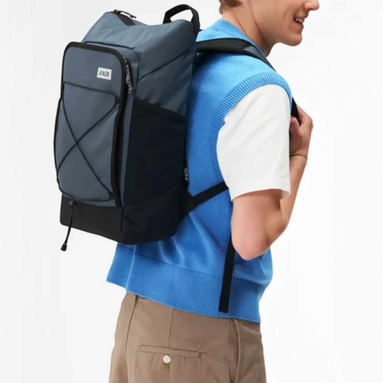 Lieblingstasche Day Pack FLX in grey and black worn by a model, featuring a front bungee cord and side pockets.