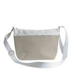 Lieblingstasche Deern Lütt crossbody bag in beige canvas with a white top trim and adjustable white shoulder strap.