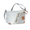 Lieblingstasche Deern Lütt crossbody bag made from recycled white and grey sailcloth with brown leather accents.
