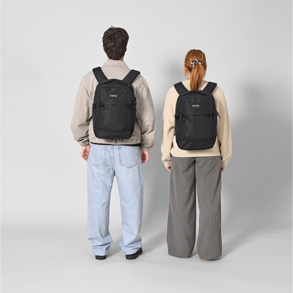 Lieblingstasche eoto Midi20 black 20L city backpack worn by a man and a woman against a light grey background