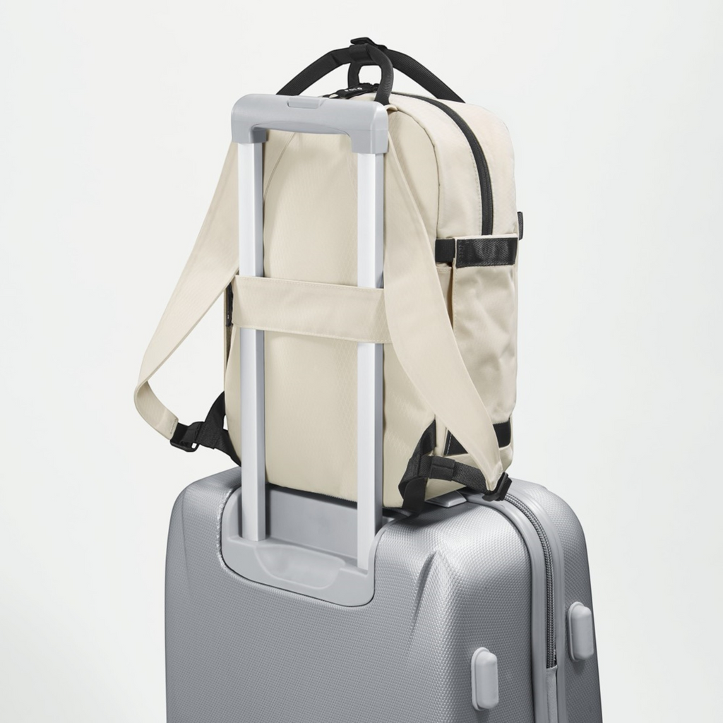 Lieblingstasche eoto Small16 beige daypack attached to a silver suitcase handle for travel