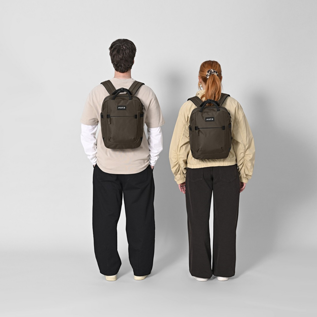 Lieblingstasche eoto Small16 compact daypack in dark brown worn by a man and a woman against a light grey background