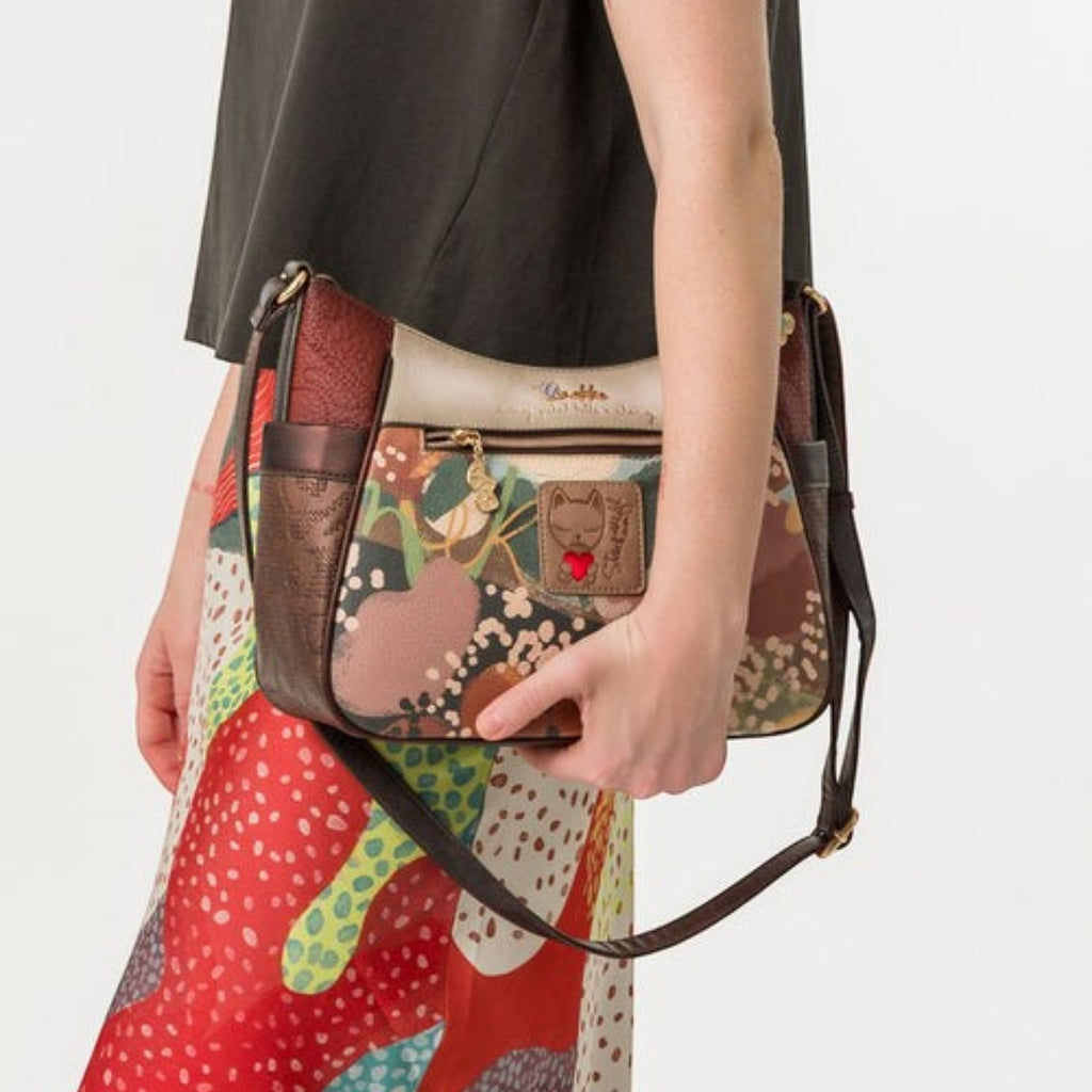 Lieblingstasche cross-body bag with a multi-colored floral pattern, brown leather trim, and a cat charm detail.