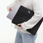 Lieblingstasche GOT BAG Rolltop Lite 2.0 black laptop sleeve being held by a person with a laptop inside