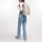 Lieblingstasche GOT BAG Rolltop 2.0 backpack in beige worn by a woman with curly hair against a white background