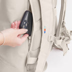 Lieblingstasche GOT BAG Rolltop Lite 2.0 backpack in beige with a hand placing a phone into the back security pocket