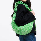 Lieblingstasche Moon Bag Ruffle Large in green leopard print worn over the shoulder by a smiling woman