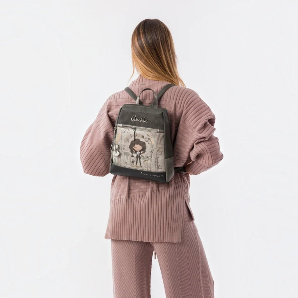 Lieblingstasche grey backpack with Anekke illustration, front zip pocket, and metallic charm on a woman's back