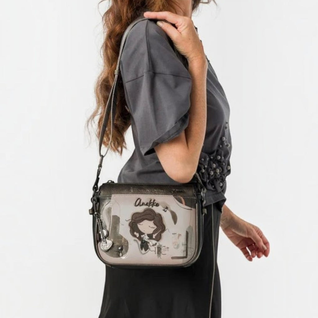 Woman wearing a Lieblingstasche grey cross-body bag with Anekke illustration and metallic details
