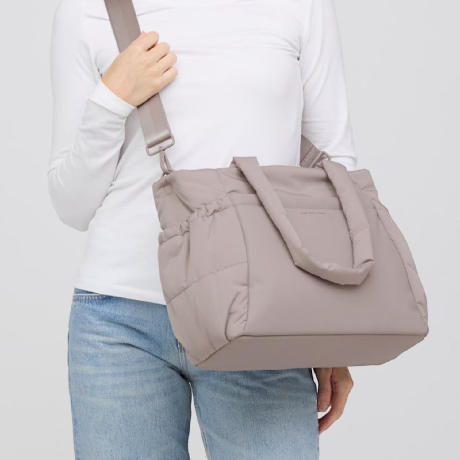 Lieblingstasche Hellvi Cloud Medium quilted taupe shoulder bag worn by a woman in a white long-sleeve shirt