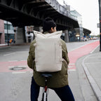 Lieblingstasche Helsinki Pro rolltop backpack in beige worn by a cyclist in an urban setting