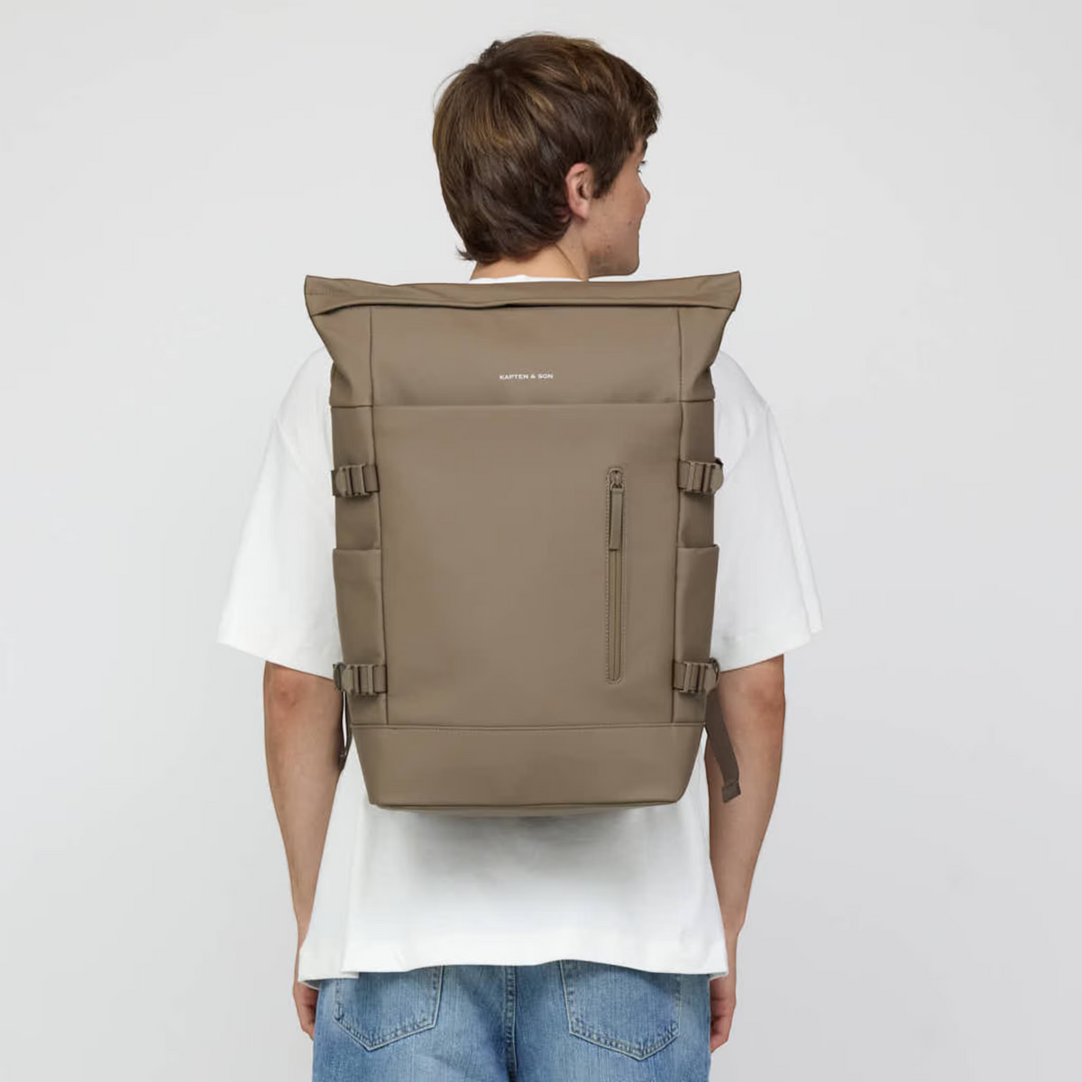 Lieblingstasche Helsinki Pro rolltop backpack in taupe worn on the back by a man in a white t-shirt