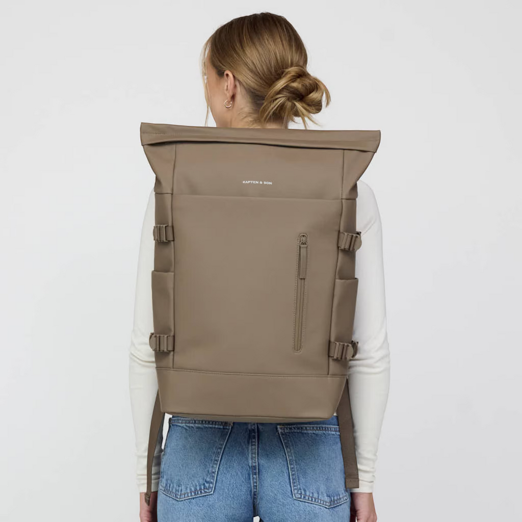 Lieblingstasche Helsinki Pro taupe rolltop backpack worn by a woman with a white long-sleeve shirt and blue jeans