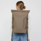 Lieblingstasche Helsinki Pro taupe rolltop backpack worn by a woman with a white long-sleeve shirt and blue jeans