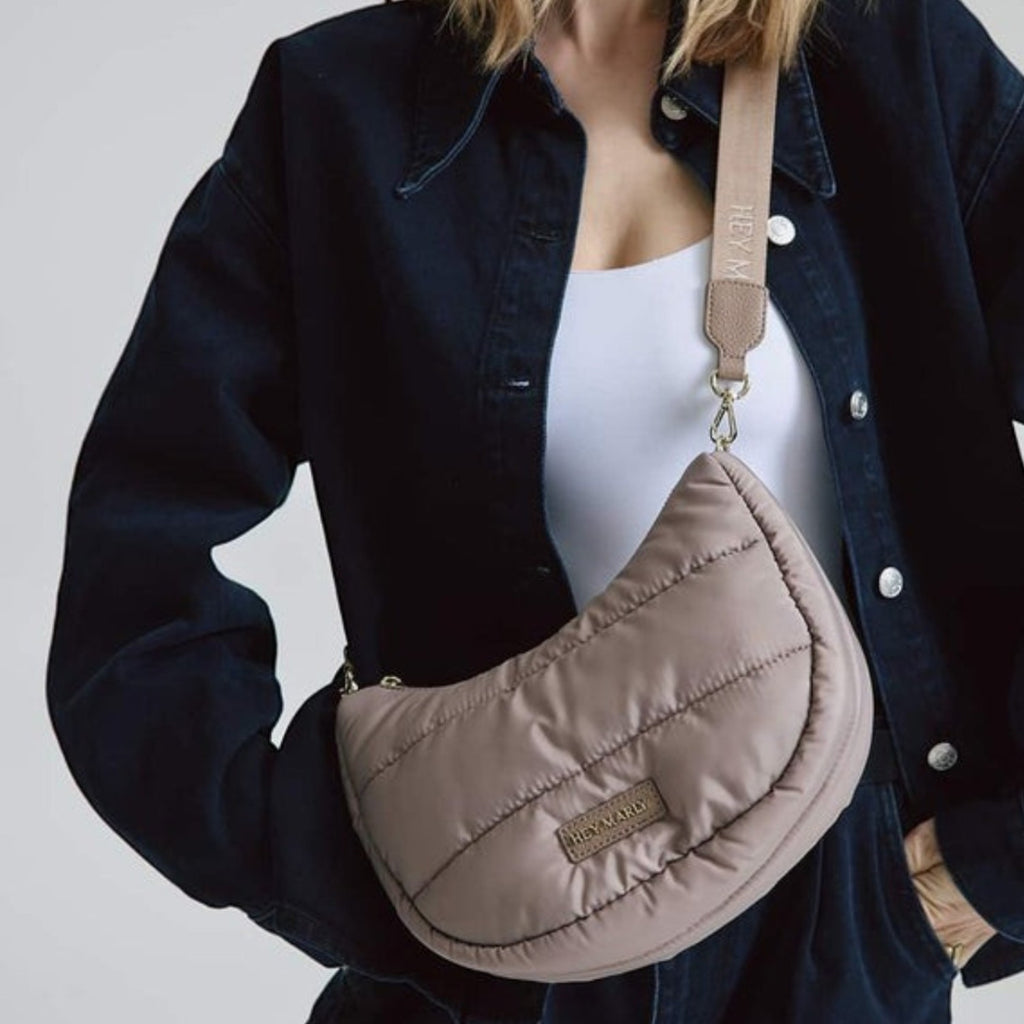 Lieblingstasche Lifetime Buddy S quilted taupe crescent crossbody bag worn by a blonde model in a dark denim jacket