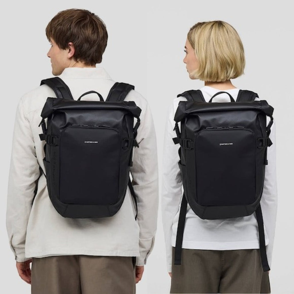Lieblingstasche Lisbon small black rolltop backpack worn by a man and a woman, featuring laptop compartments.