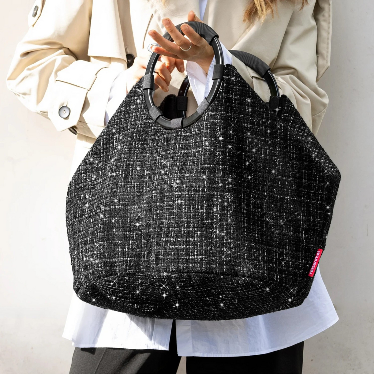 Lieblingstasche Loopbag Hobo in black textured fabric with sparkling glitter details and round black handles.