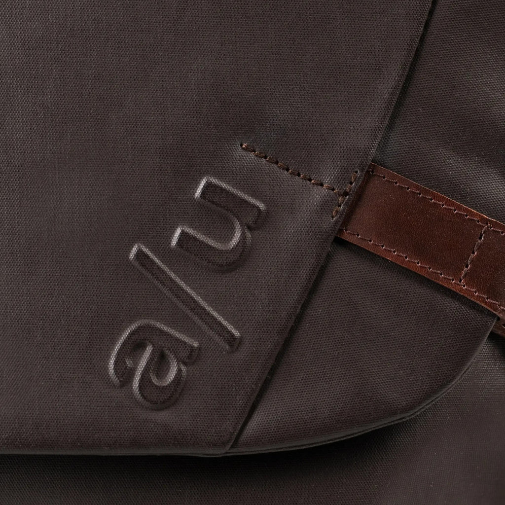 Close-up of the Lieblingstasche Matsumoto bag in dark brown fabric with embossed a/u logo and brown leather detail