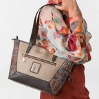 Lieblingstasche shoulder bag in metallic gold and brown with textured side panels carried by a woman