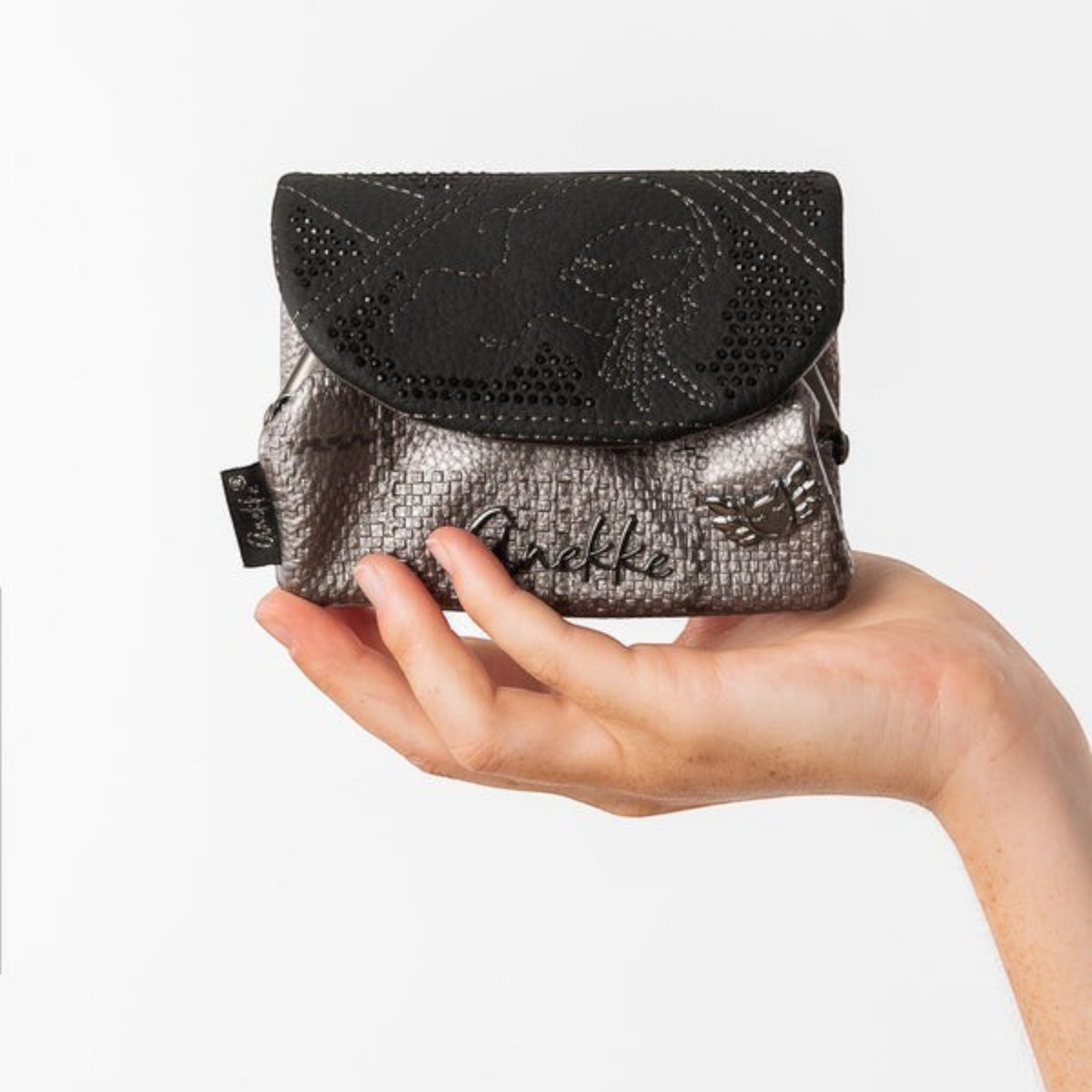 Lieblingstasche metallic grey and black Anekke purse with textured finish and decorative embellishments held in hand