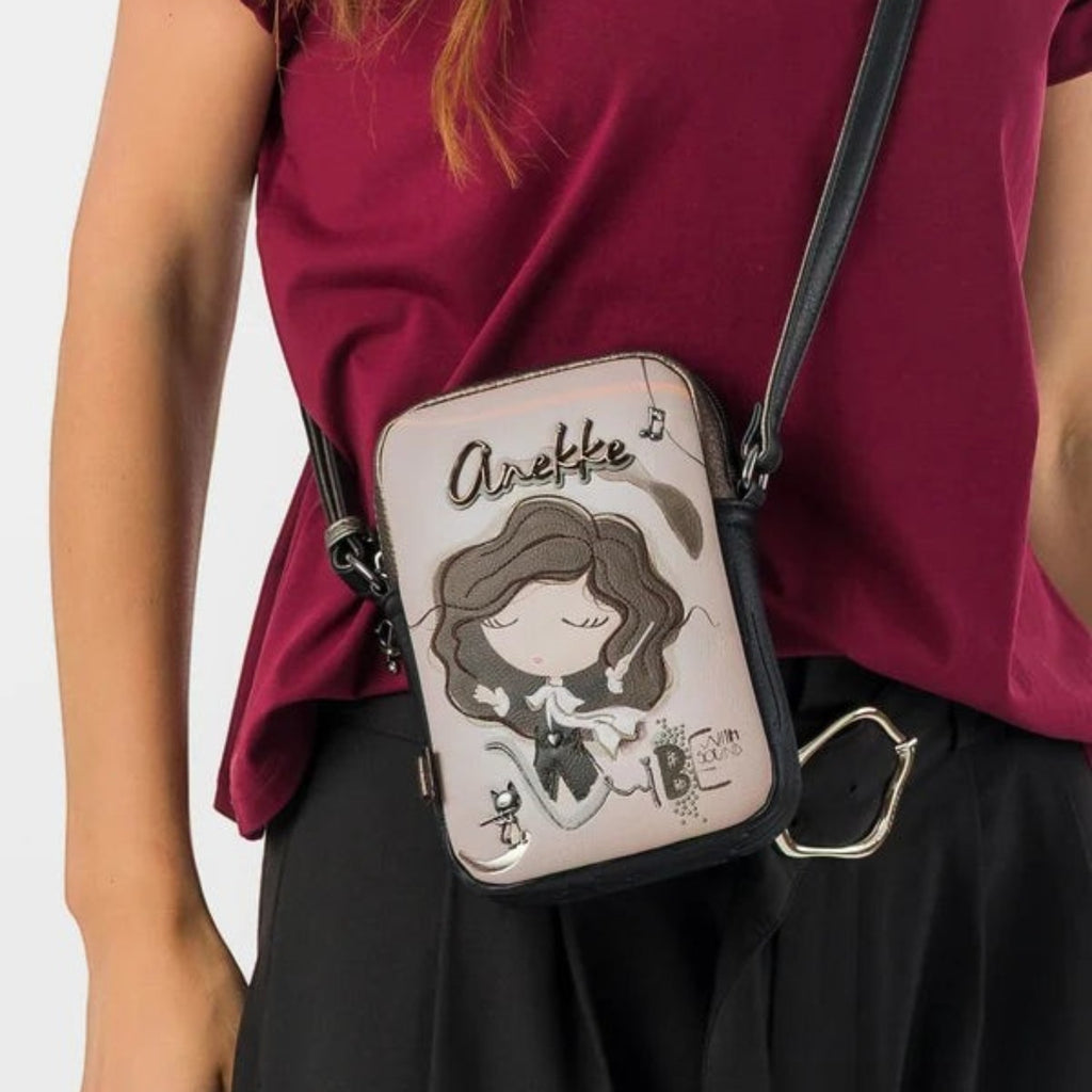 Lieblingstasche mini cross-body bag featuring a whimsical Anekke illustration in beige and black on a woman