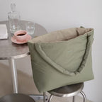 Lieblingstasche Norva 2in1 reversible shopper bag in sage green with padded handles on a stool