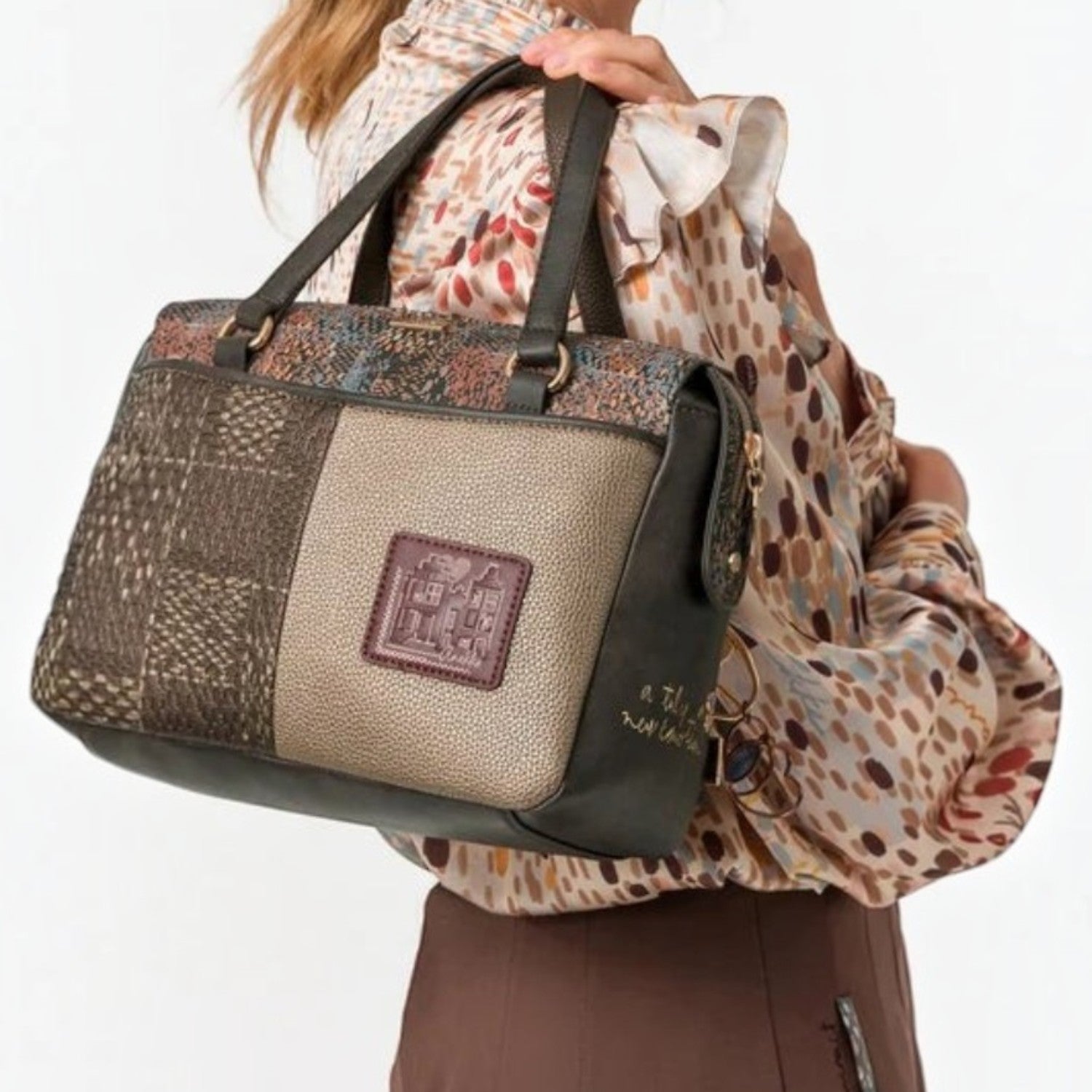 Lieblingstasche short handle bag featuring a multi-textured brown and metallic patchwork design carried on shoulder