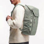 Man wearing a sage green Lieblingstasche Pro Pack laptop backpack with ergonomic straps and side mesh pockets